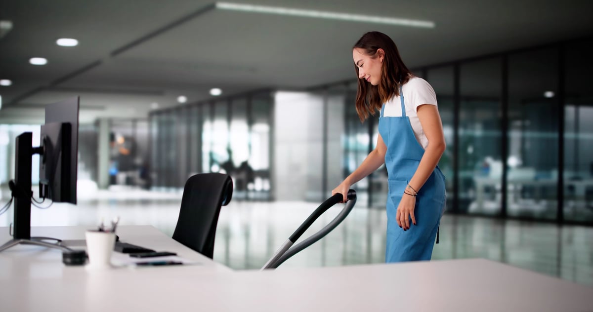 Professional cleaner maintaining a sparkling corporate office workspace