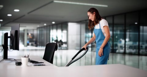 Professional cleaner maintaining a sparkling office workspace in London