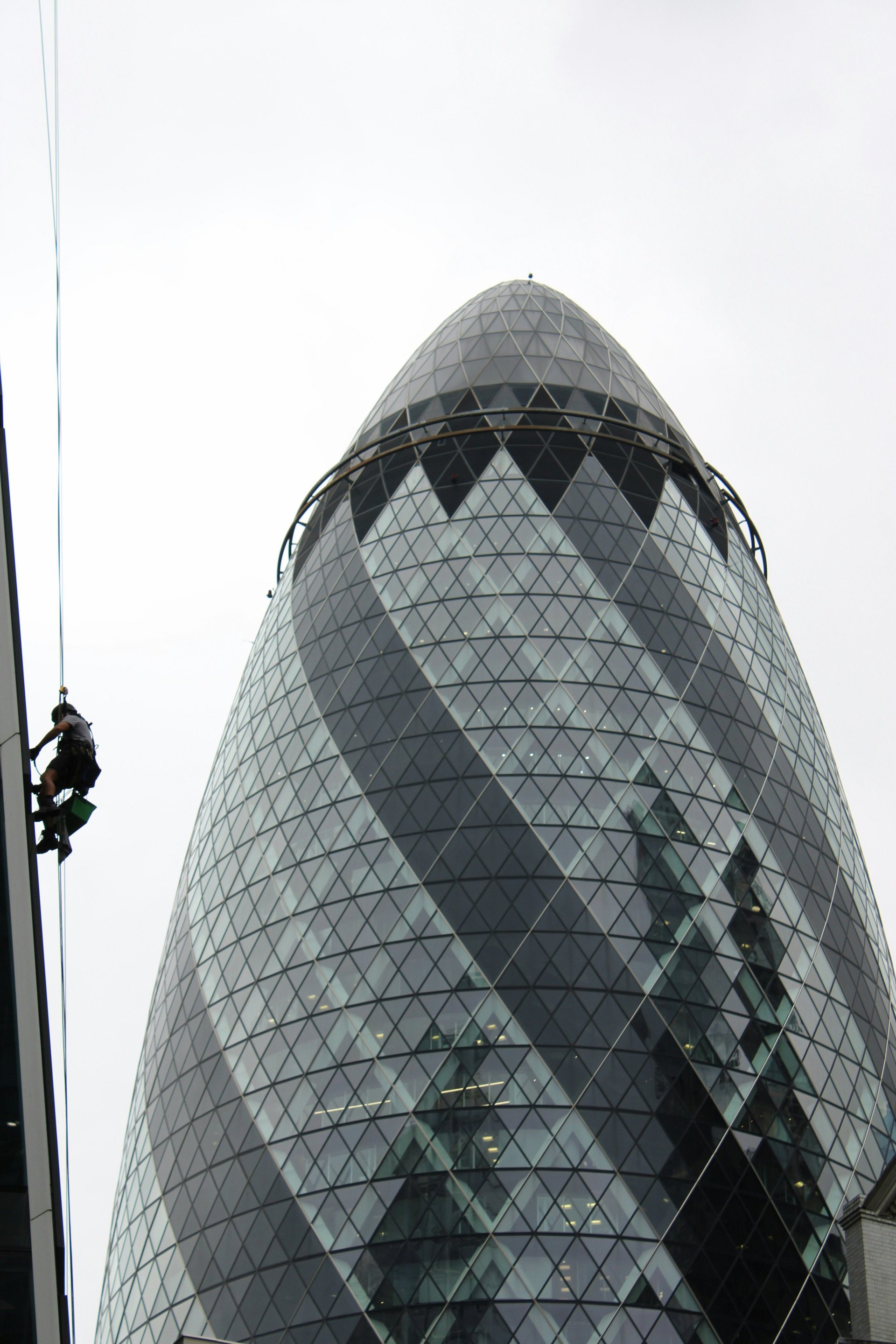 Modern glass cone-shaped skyscraper with geometric diamond pattern facade